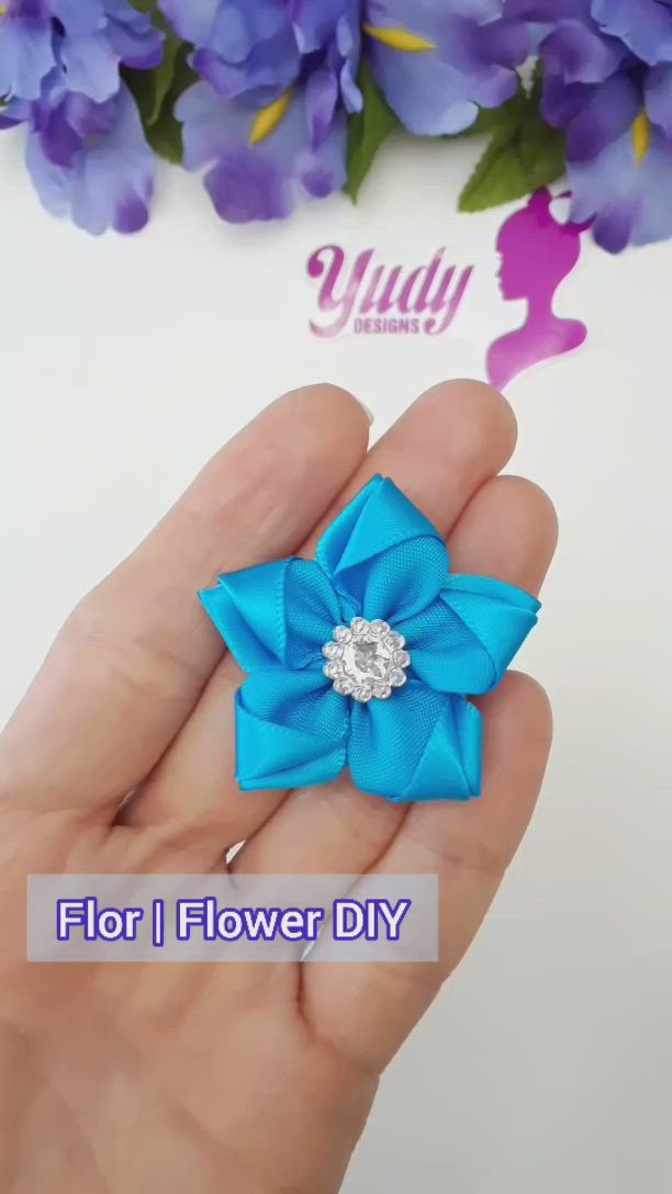 This may contain: a person holding a flower in their hand with the words, flor i flower diy