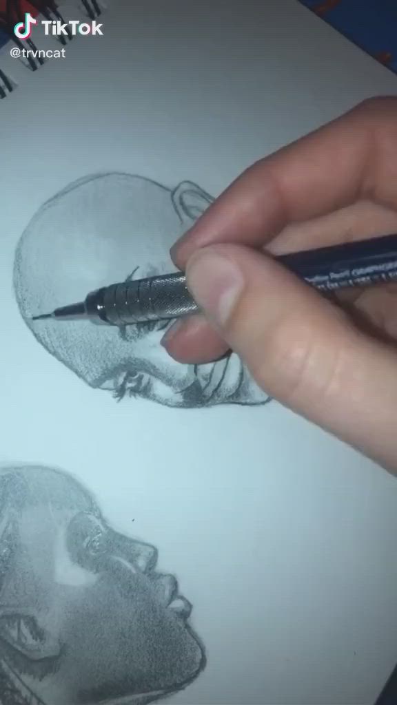 This may contain: a person is holding a pen and drawing a man's head with a pencil