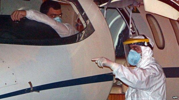 A Brazilian technician waits beside plane to take first Ebola suspected case to Rio 10 October 2014