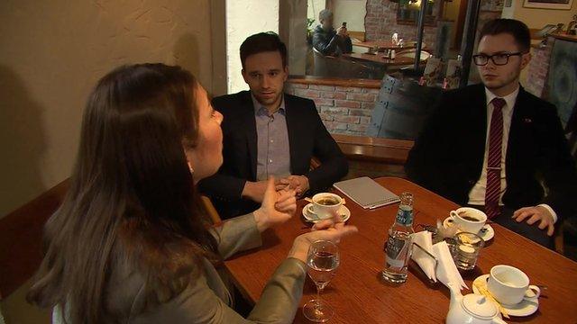 Katya Adler in a coffee house with two Lithuanian students