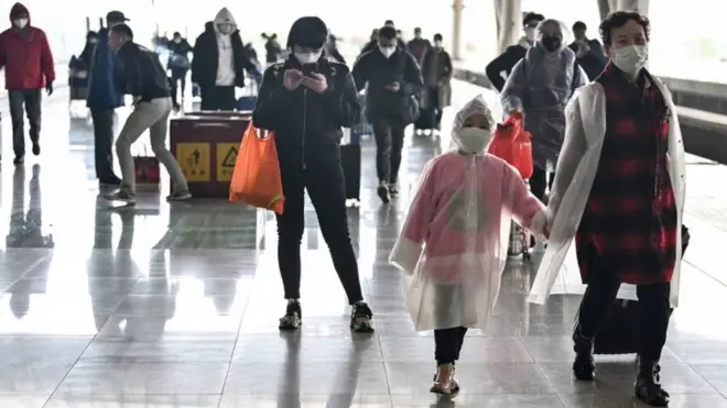 Passengers arrive at the railway station in Wuhan, China's central Hubei province on 28 March 2020, after travel restrictions into the city were eased