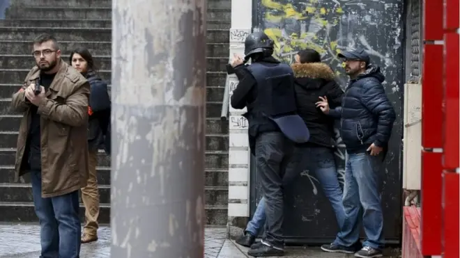 French police check a pedestrian as they secure the area after a man was shot dead at a police station in the 18th district in Paris, France 7 January 2016