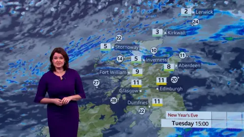 Weather presenter Gillian Smart wears a purple dress and stands in front of a green screen showing heavy rain forecast across much of Scotland at 3pm on New Year's Eve.