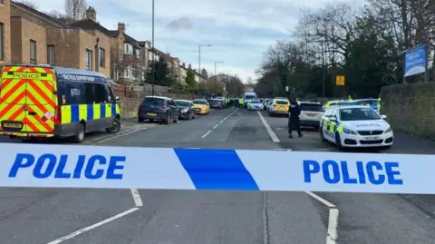 Tom Ingall/BBC Cordon outside entrance of All Saints Catholic High School in Sheffield