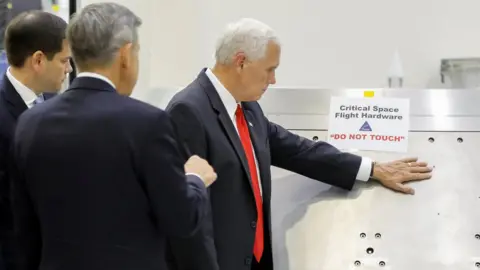 Reuters US Vice-President Mike Pence touches a piece of hardware with a warning label "Do Not Touch" at the Kennedy Space Center, 6 July 2017