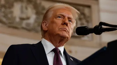 Donald Trump looks up from a podium in a close-up.