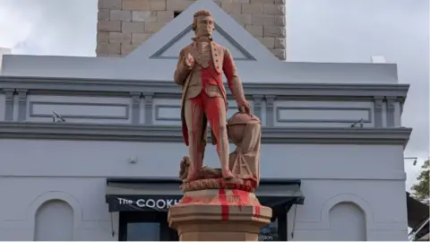 Red paint covers a statue of Captain Cook in Sydney