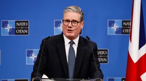 Keir Starmer speaking at a Nato press conference next to a Union Jack