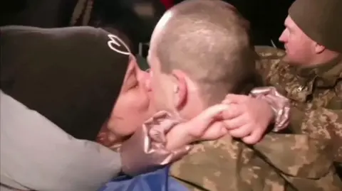 A woman embraces a man released in Ukraine in a prisoner exchange with Russia