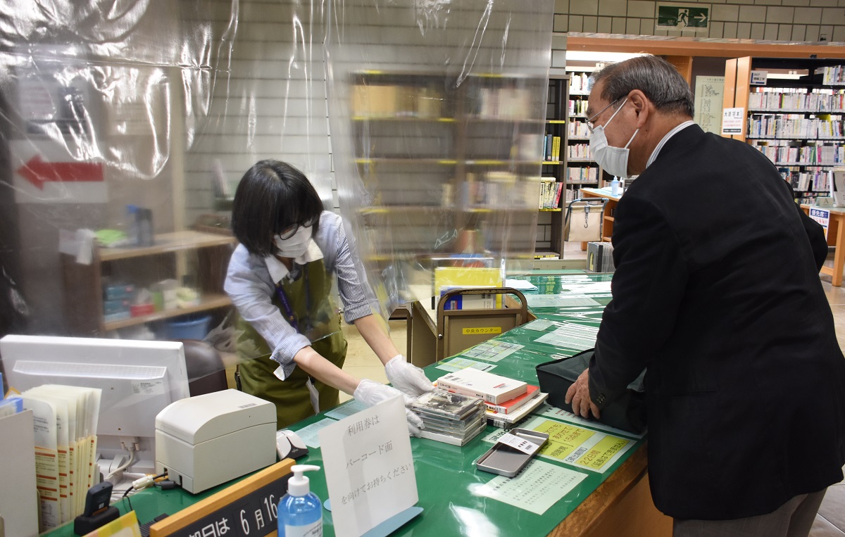 職員はマスクと手袋を着用し、貸し出しの受け付けはシート越しに=2020年5月26日、前橋市の群馬県立図書館