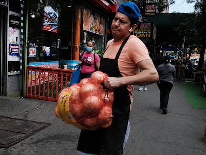 Un trabajador de origen latino carga un costal de cebollas en Manhattan (Nueva York), en junio de 2021.