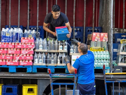 Dos trabajadores reparten bebidas para hostelería en Madrid.