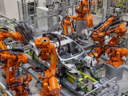 Robots industriales trabajan en la carrocería de un Porsche Macan totalmente eléctrico en la planta de Leipzig (Alemania).