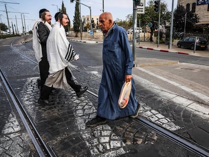 Dos judíos y un musulmán se cruzan por la calle que separa la parte este de la oeste de Jerusalén, el 28 de octubre de 2023.