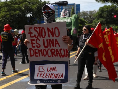 Unos manifestantes portan banderas y carteles durante una protesta para conmemorar la masacre de estudiantes salvadoreños de 1975, el 30 de julio de 2024 en San Salvador, El Salvador.