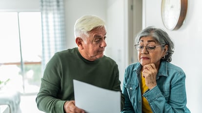 Una pareja de adultos mayores revisa sus finanzas en su hogar.