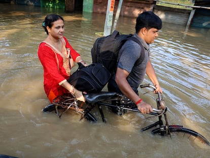 Una pareja en bicicleta el 19 de septiembre en la zona de Uday Narayanpu (India), que sufrió severas inundaciones provocadas por las fuertes lluvias.