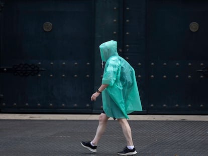 Una hombre se cubre de la lluvia con un impermeable, este miércoles en Málaga.