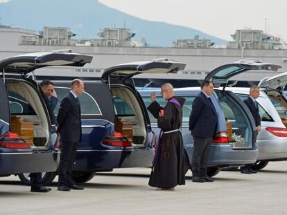 Un sacerdot beneeix els cadàvers dels italians morts en l'atemptat de Tunis, aquest dissabte a prop de Roma.