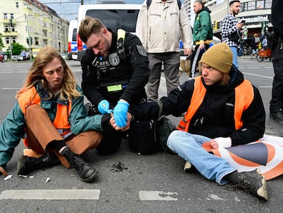 Un agente de policía trata de despegar las manos de dos activistas de Letzte Generation durante una acción de protesta en Berlín el 25 de abril pasado.