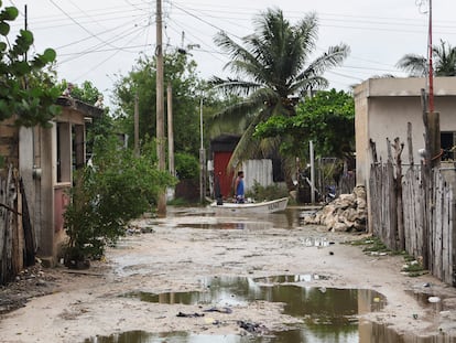 Un hombre transporta a su hijo en un bote a través de una calle inundada tras el paso del huracán Milton, este martes en Celestún (Yucatán).