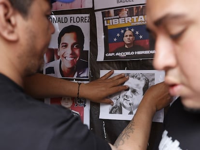 Ciudadanos venezolanos pegan fotografías de presos políticos detenidos en Venezuela, durante una manifestación en la Plaza de Bolívar en Bogotá.