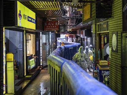 Personal sanitario dentro de la valla que confina la ciudad de Guangzhou, a finales de noviembre.