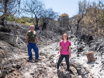 Los vecinos de Casas de Miravete, Gemma Suárez y su marido Juan, en el huerto de su finca, que se ha quemado durante el incendio de Monfragüe, en Cáceres.