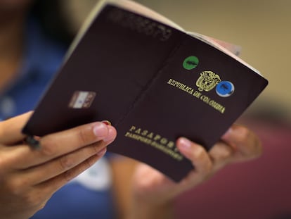 Una ciudadana colombiana mira su pasaporte mientras rellena papeleo en Florida (EE UU), en una fotografía de archivo.