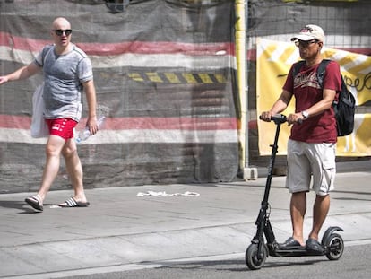 Un home circula amb un patinet elèctric per Sants, a Barcelona.