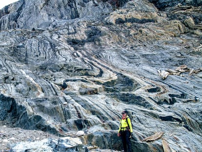 La coautora de la investigación, Athena Eyster, junto a una porción del cinturón de rocas verdes de Isua en el que se aprecian vetas alternativas de cuarzo (las blancas) y magnetita que conserva la señal magnética.