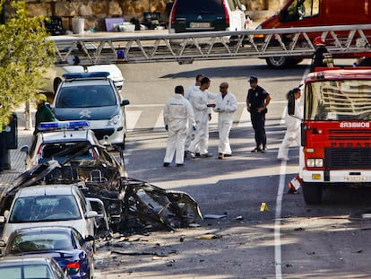 Agentes de la policía y bomberos junto al vehículo de la Guardia Civil destrozado por una bomba colocada por ETA, en Mallorca, el 30 de julio de 2009.