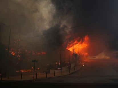 Un edificio de secundaria y su gimnasio se ven en llamas mientras arde un incendio forestal en Nea Penteli.