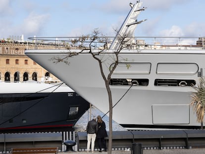 Dos turistas observan los yates en el Port Vell.