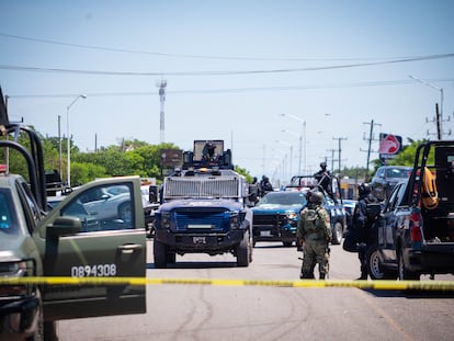 Efectivos de la SEDENA, la policía estatal y personal de tránsito municipal retiran vehículos después de un enfrentamiento en Culiacán, Sinaloa.