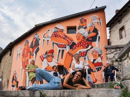 L'artista Marina Capdevila (Falset, 1985) posa davant del mural que va pintar a Aielli, una petita vila medieval d'Itàlia en companyia d'algunes de les veïnes amb qui va inspirar-se.