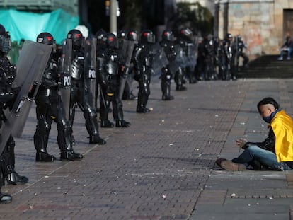 Un manifestante se sienta frente a una fila de policías, el 21 de septiembre de 2020, en Bogotá.