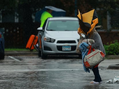 Una mujer sostiene un paraguas mientras llega a un refugio al acercarse el huracán Milton, en Lakeland, Florida, el 9 de octubre de 2024.