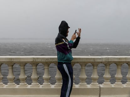 Un  hombre graba con su teléfono móvil entre las fuertes lluvias previo a la llegada del huracán Milton, el 9 de octubre en Tampa (Florida).