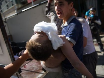 Un hombre traslada el cad&aacute;ver de un ni&ntilde;o muerto ayer en un ataque del Ej&eacute;rcito contra una panader&iacute;a en el este de Alepo.