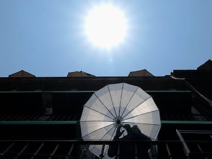 Un trabajador de las terrazas del Zócalo se resguarda del sol en Ciudad de México, este 1 de mayo.