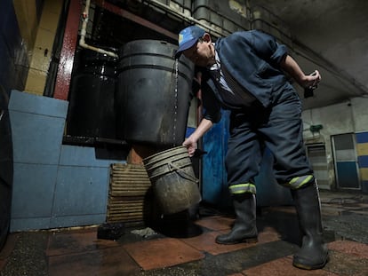 Un trabajador llena una cubeta con agua recolectada en el barrio Marsella, en Bogotá, durante el racionamiento impuesto por la alcaldía en abril de 2024.