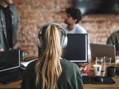 Una mujer en el trabajo con auriculares.