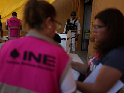 Un miembro del Ejército Mexicano reguarda a trabajadores del Instituto Nacional Electoral en Ciudad Juárez.