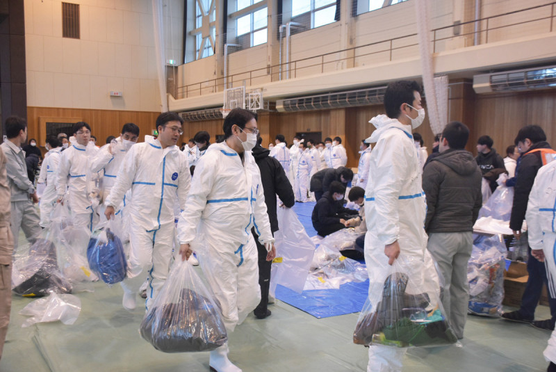 防護服に着替え、養鶏場へと向かう県職員ら＝２日、盛岡市・渋民運動公園総合体育館