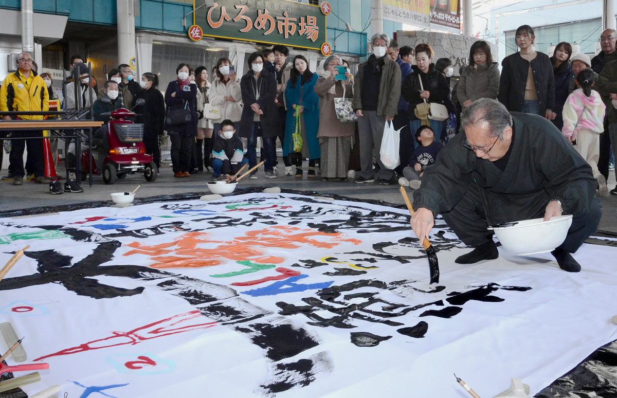 豪快な揮毫を披露した高野奇峭さん（高知市のひろめ市場）