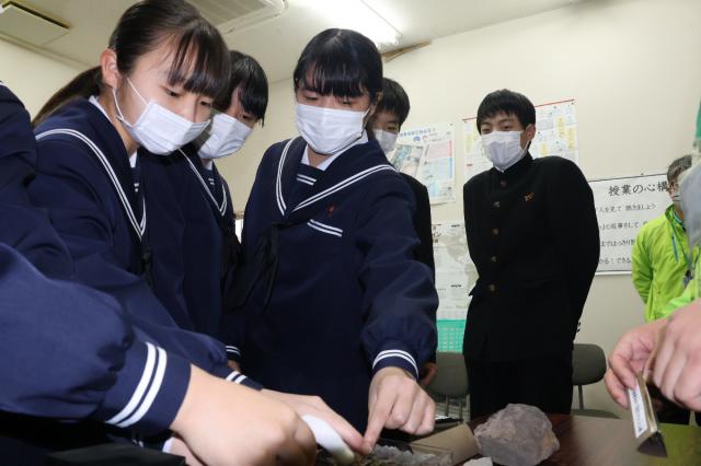 新燃岳の噴火で降った噴石に触れ、防災意識を高めた生徒たち＝２４日午前、高原町・後川内中