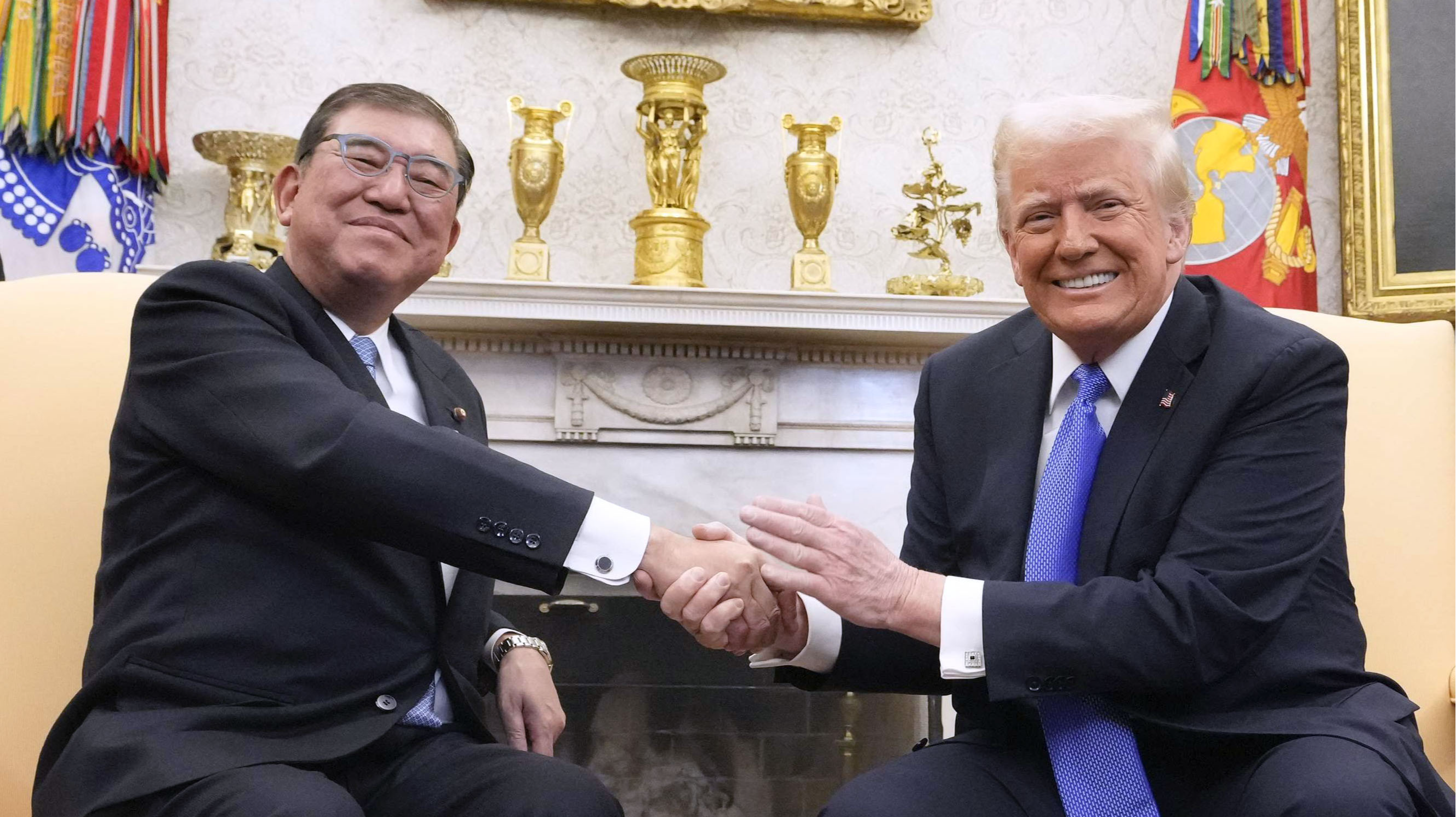 首脳会談で握手を交わす石破首相（左）とトランプ米大統領＝7日、ワシントンのホワイトハウス（共同）