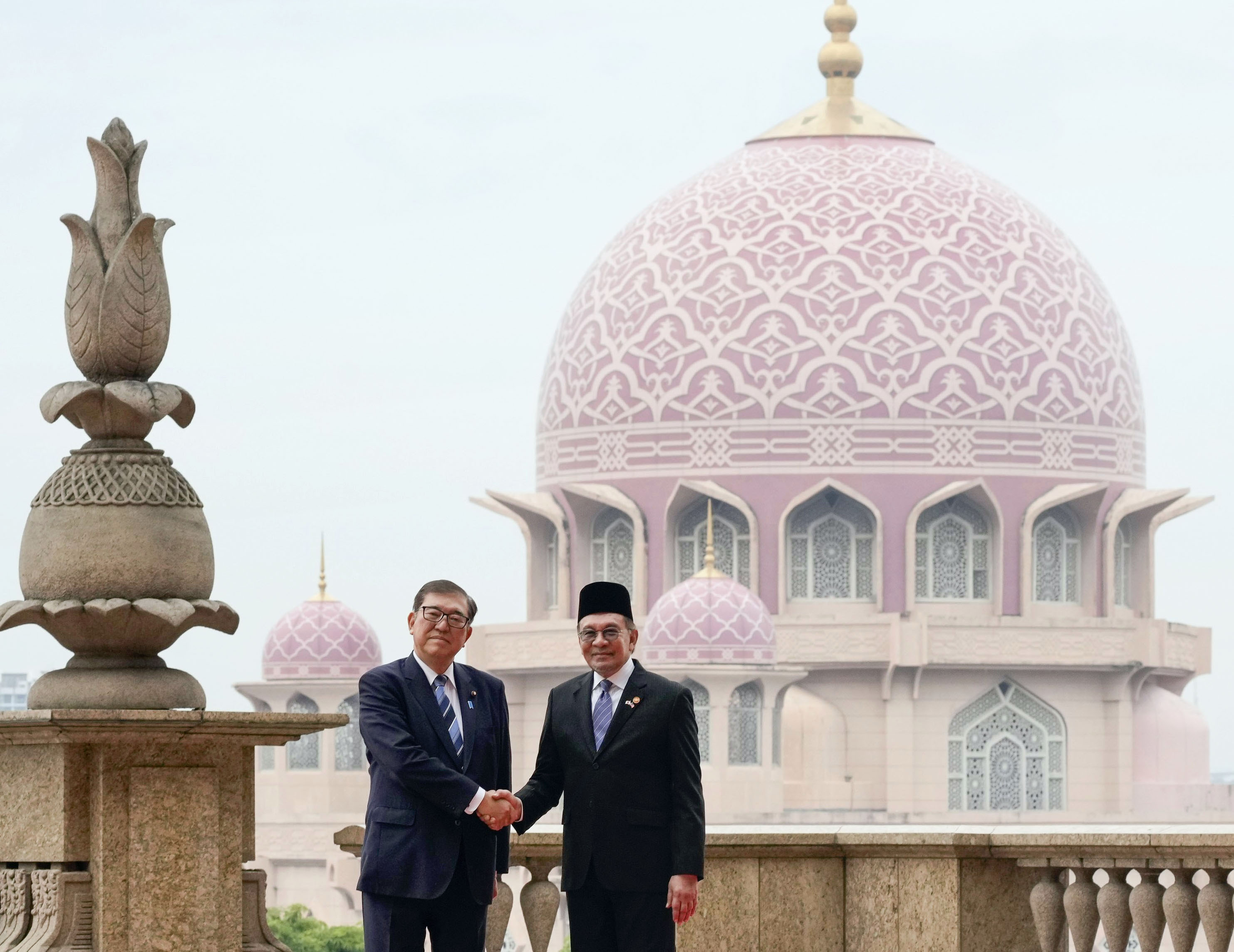 首脳会談を前に、マレーシアのアンワル首相（右）と握手する石破首相＝10日、クアラルンプール近郊の首相府（共同）