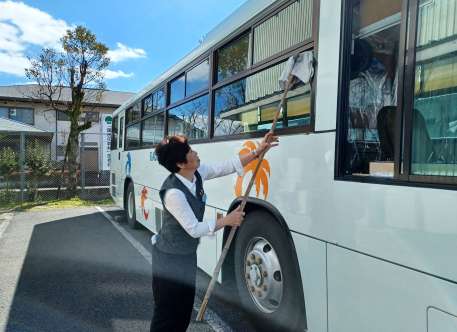 乗車後のバス車体を磨き上げる運転手の大東千代子さん＝鹿児島市浜町